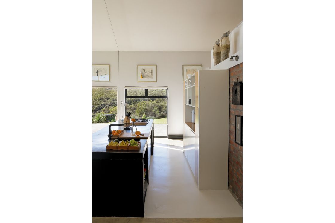 A modern kitchen showcasing a large central island and brick wall, enhancing the design.