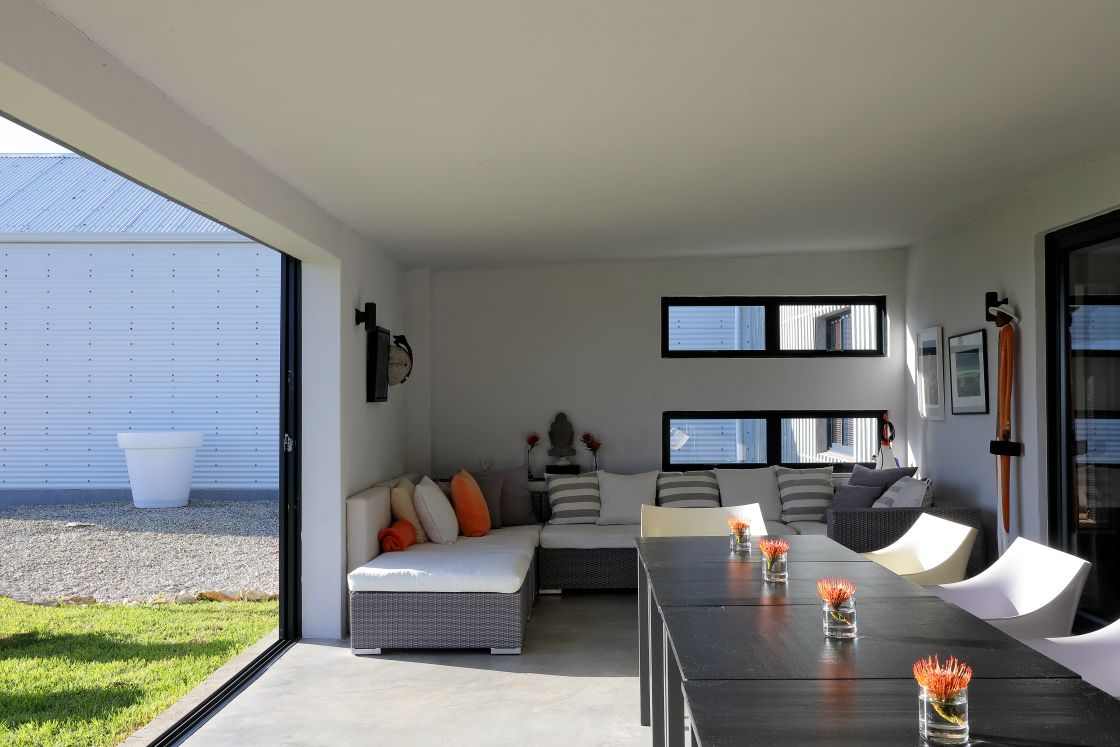 A contemporary patio featuring a stylish table surrounded by comfortable chairs.