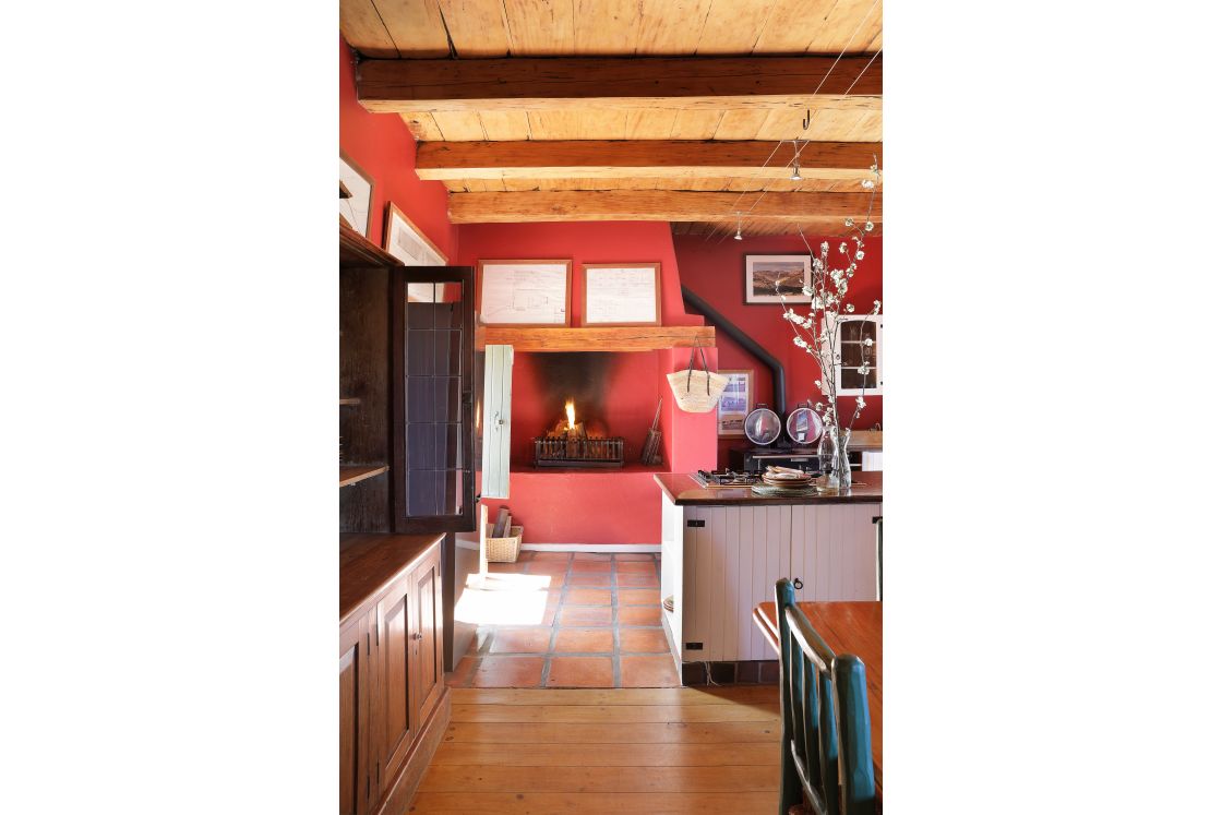 Dining room of the main house's indoor fireplace and kitchen island, the room has wooden floors and ceilings.