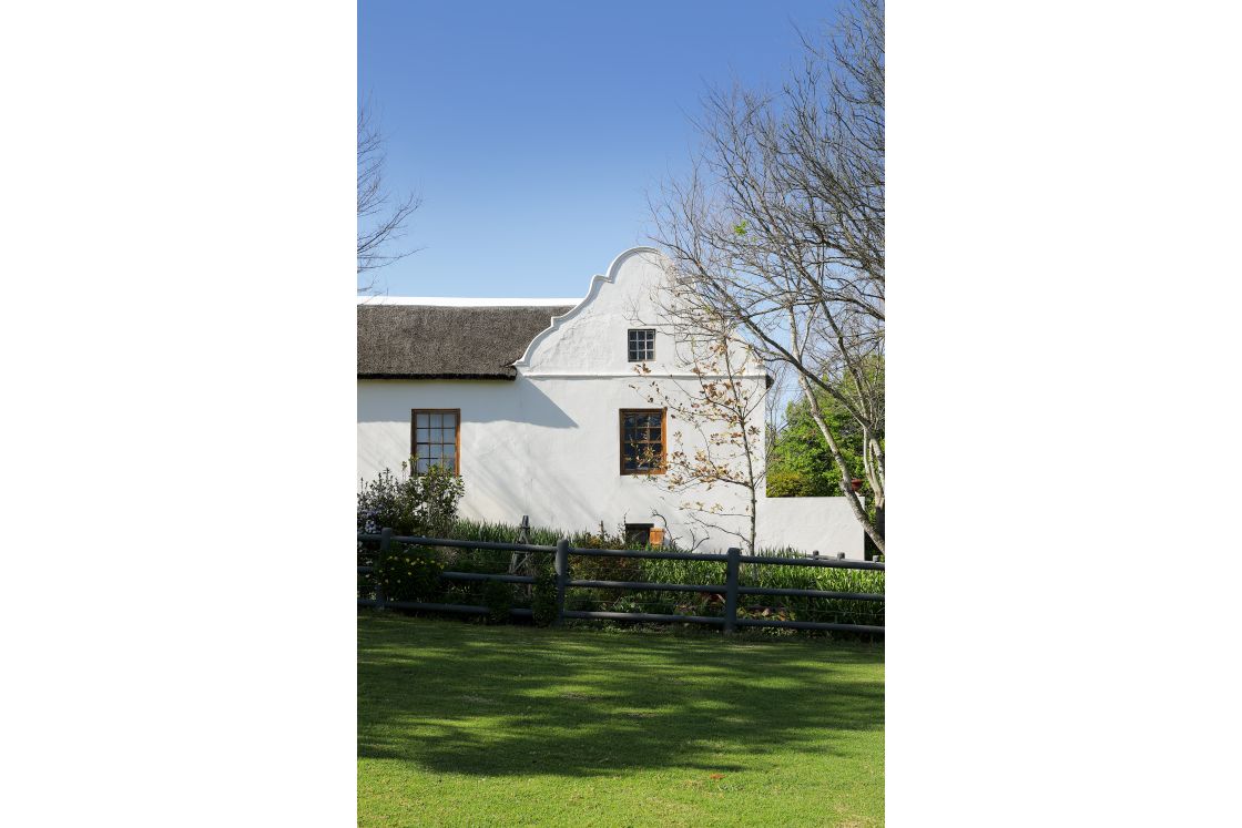 Cape Dutch homestead with lawn and garden fence. Garden Route.