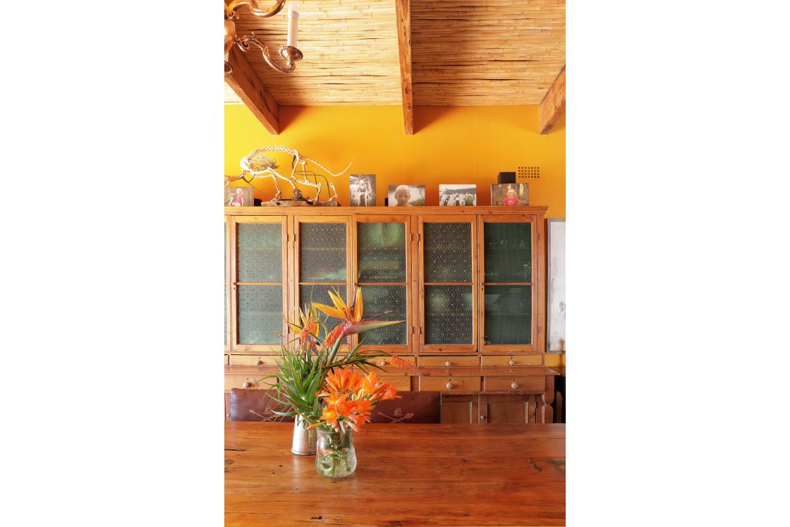 Wooden cupboards with frosted glass doors and small drawers the cupboard is adorned with photographs and decorative elements.