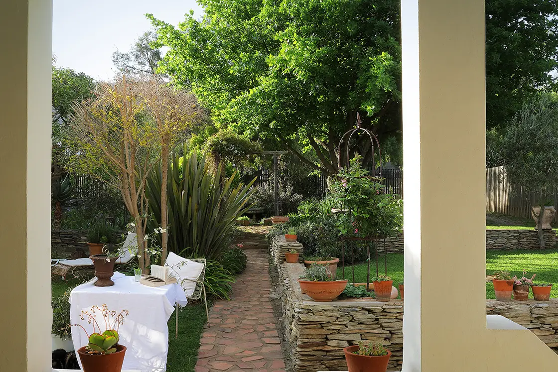 Perfect Hideaways real estate property: Natural stone garden path leading guests into the well-kept garden, potted succulents and small plants decorate the stone wall. The White House in Barrydale.