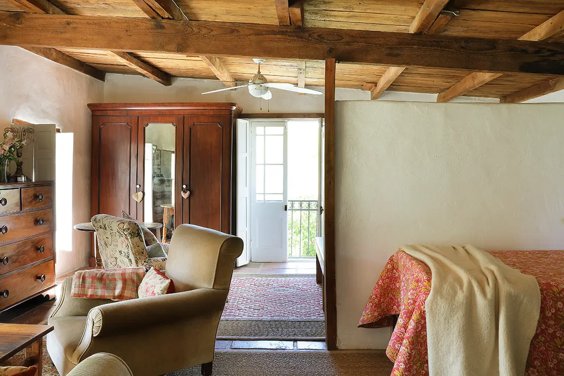 Perfect Hideaways real estate property: Bedroom with rustic wood decor and ceiling contrasting the neutral tone of the comfortable chairs and single bed. The White House in Barrydale.