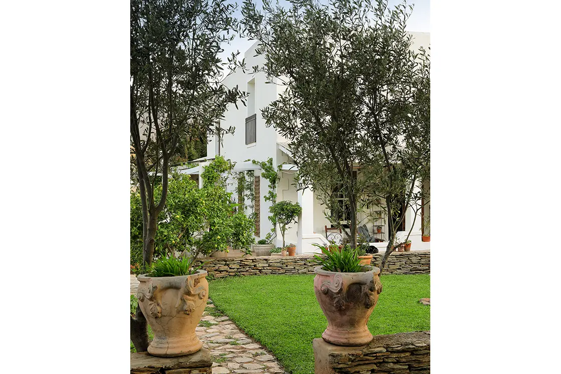 Perfect Hideaways real estate property: Large plant pots on a stone wall frame a natural stone path to the heritage guesthouse. The White House in Barrydale.