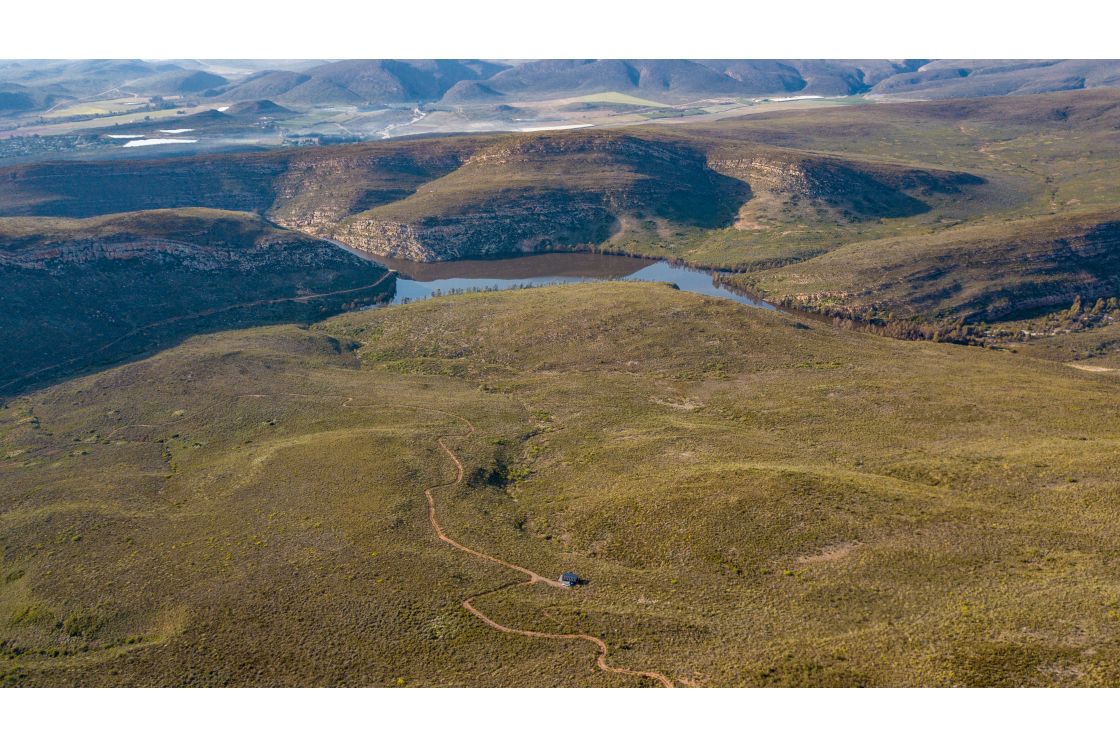 An aerial photo of a plot of land for sale near Robertson, Western Cape, showcasing a river with tributaries flowing from the various slopes of this dynamic landscape.